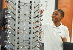 Local student chooses a favorite pair of frames for his free eyeglasses from IFB and Luxexcel