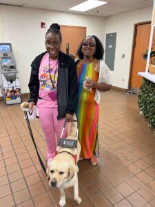 A Winston-Salem facility employee and their guide dog at the 90th anniversary ice cream event.