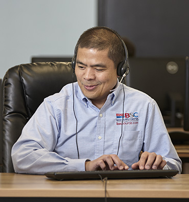 A BSC customer service representative answers calls at his desk at IFB Solutions in Winston-Salem.