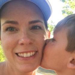 Woman getting a kiss on the cheek from her son while outdoors