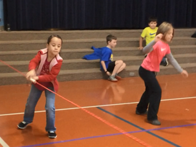 Girl uses rope guide to run along sighted peers in PE class