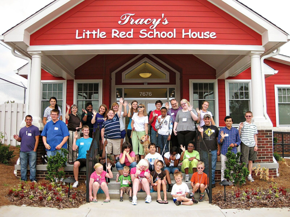 Kids from summer camp sit on the steps of Tracy's Little Red Schoolhouse