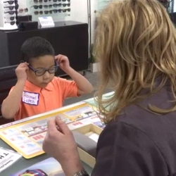 Young boy tries on his new glasses for the first time