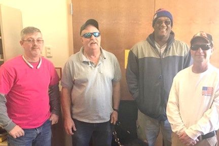 Four men, members of the IFB Solutions Veterans Support Group, pose for a photo