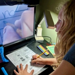 Young girl uses assistive technology for homework