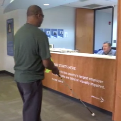 Man walks into IFB Solutions lobby using a cane