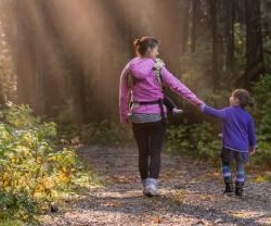Mom and kid walk in forest