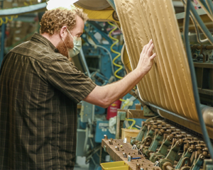 man working with textile manufacturing machinery