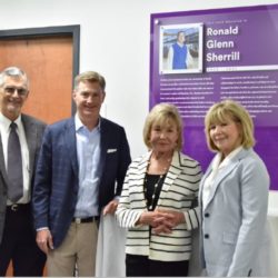 Members of the Sherrill family stand in front of the Ronald G. Sherrill dedication plaque