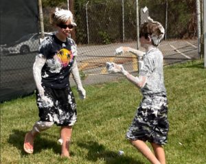 two kids playing outside, covered in shaving cream