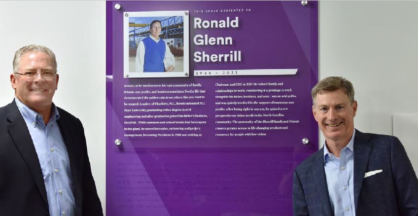 Ed Rose and Glenn Sherrill flank the dedication plaque for the Ronald Glenn Sherrill Community Low Vision Center in Winston-Salem, NC