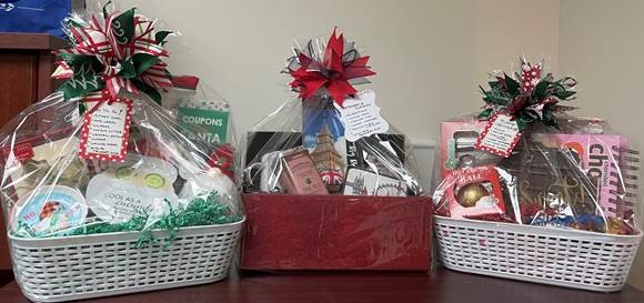 Photo of three gift baskets featuring a variety of items.