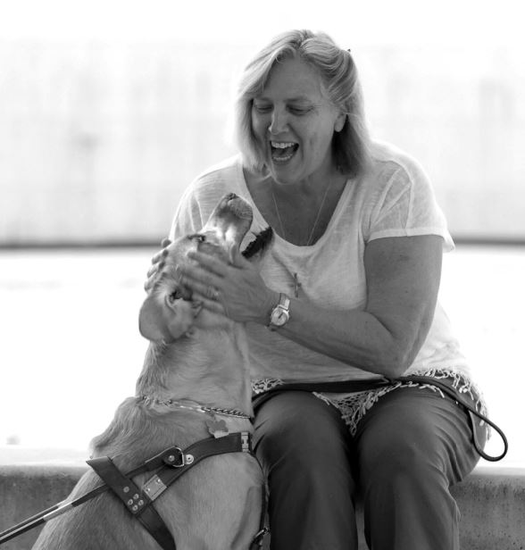 Woman who is blind pets guide dog 
