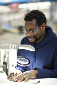 IFB Solutions employee Clayton Sanders, sewing pockets on extreme weather garments to by worn by the U.S. Army