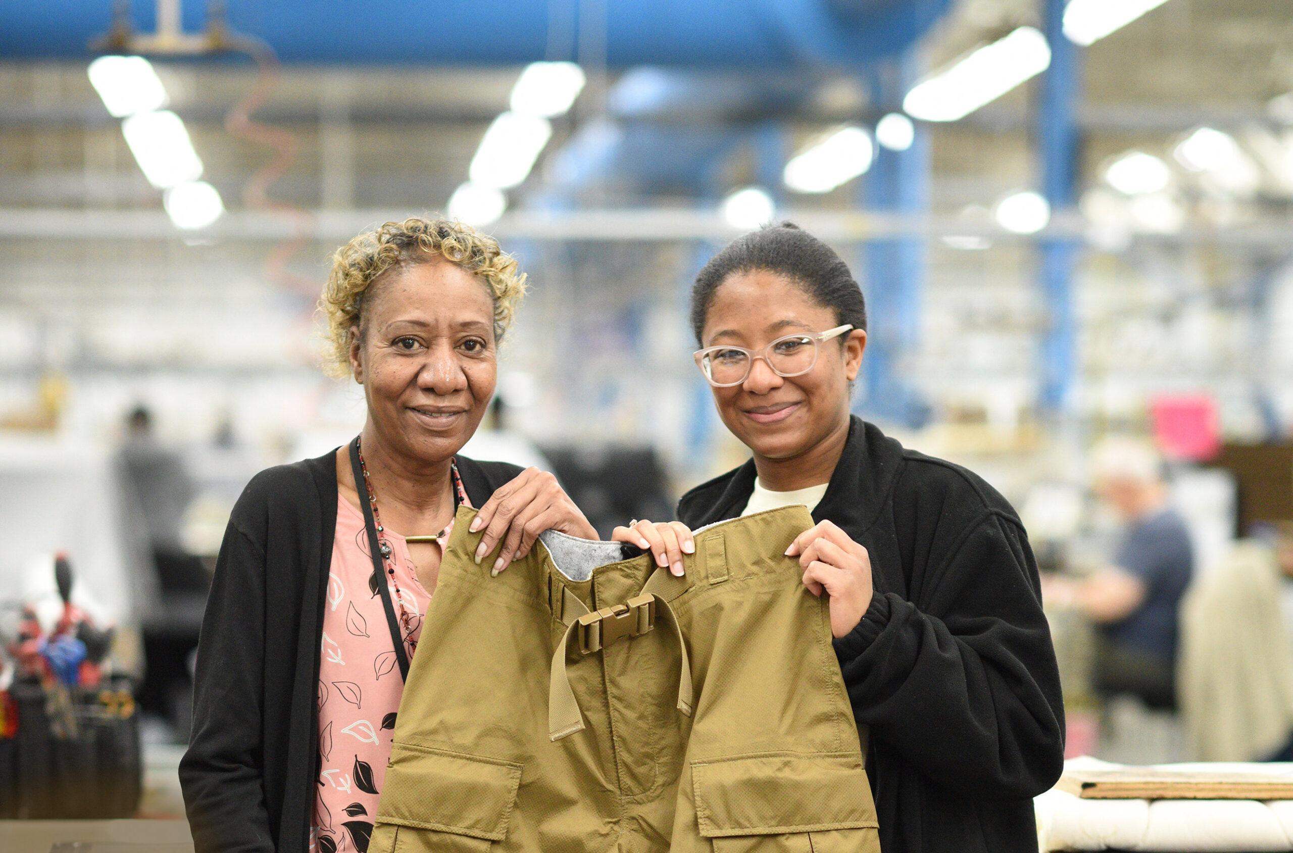 IFB Solutions employees JoAnn Dean (left), and Denesha Scales (right) holding a Fuel Handler’s Suit