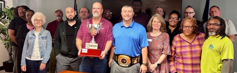 Winston-Salem plant leadership pose with the 5S trophy and belt