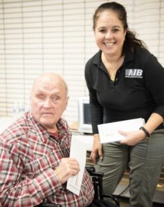 NIB representative distributes an envelope to an Asheville Facility employee