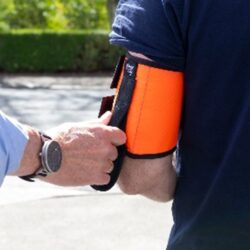 Man holding ramble tag affixed to another person's arm.