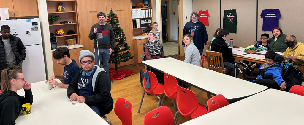 Dan Kelly stands with SEE students in the main room of the schoolhouse