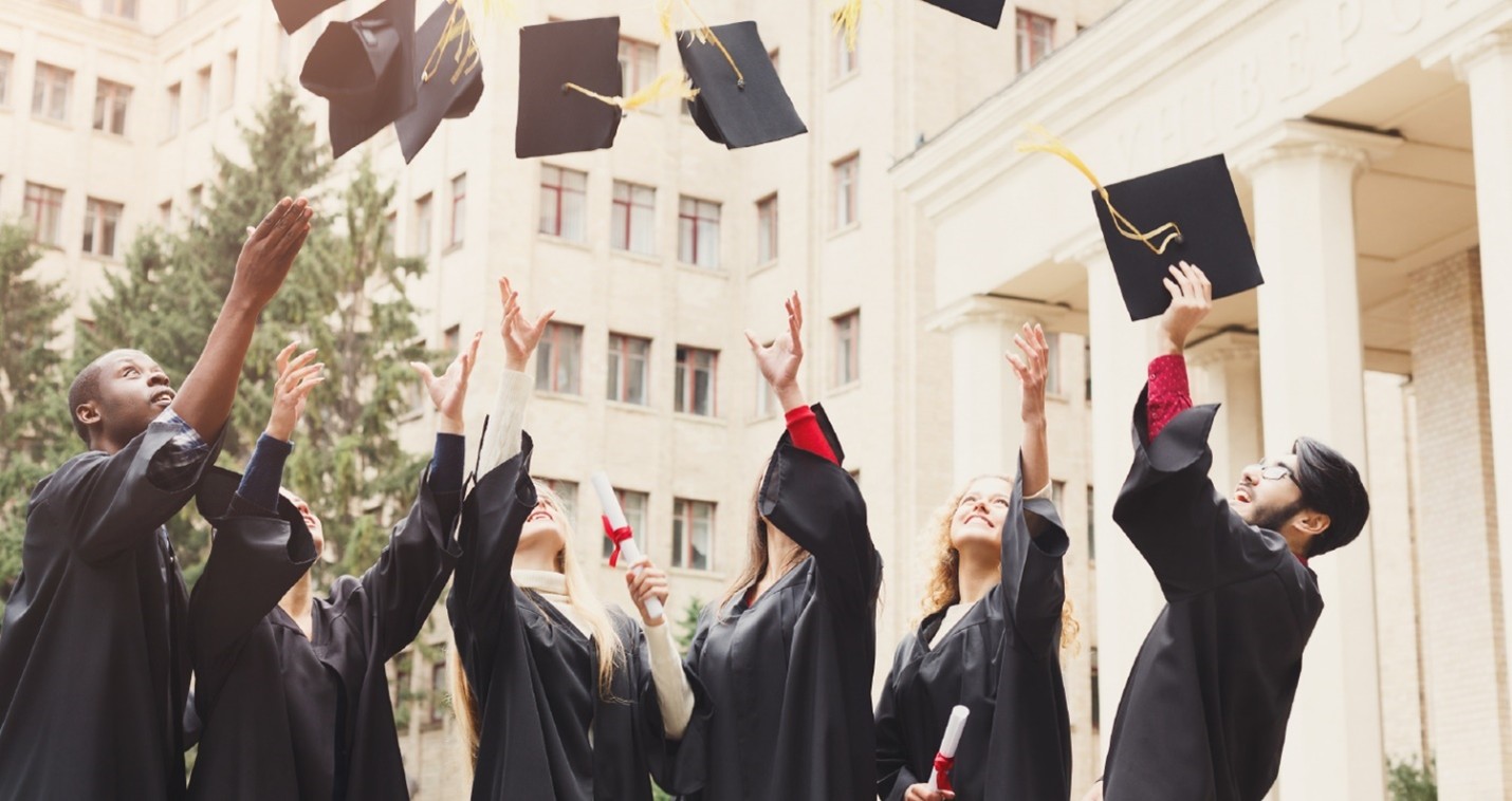 Graduates throwing graduation caps