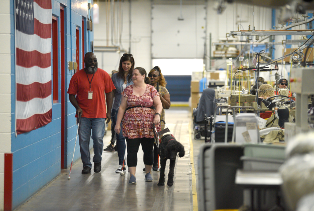 group of employees use canes and guide dog to navigate the plant floor