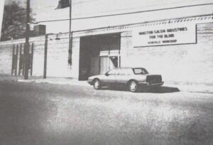 The outside of the IFB Solutions Asheville facility in the 1990s. A car sits out front.